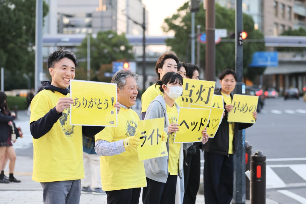 「ありがとう」のプラカードを掲げる様子
