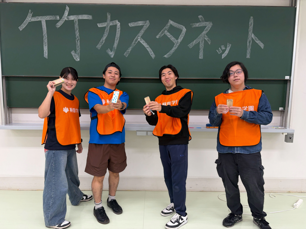 竹カスタネットを手にする学生プロジェクトCANDLEの学生